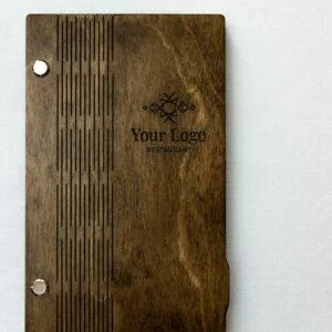 Drewniane etui na rachunek z laserowo wygrawerowanym wzorem pionowych linii, metalowymi nitami i przykładowym miejscem na logo restauracji, na jasnym tle.