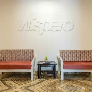 Logo Wispero 3D z MDF w kolorze ściany nad sofami w poczekalni